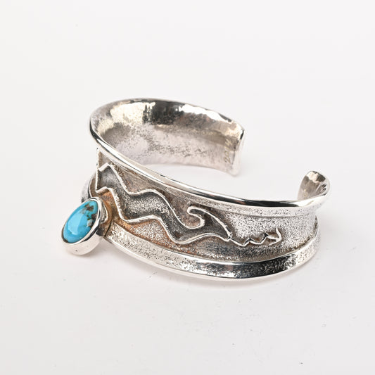 Tufa-cast, Sterling Silver Cuff Bracelet decorated with Avanyu (water serpent) and one Turquoise stone