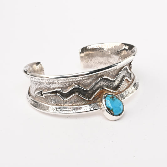 Tufa-cast, Sterling Silver Cuff Bracelet decorated with Avanyu (water serpent) and one Turquoise stone