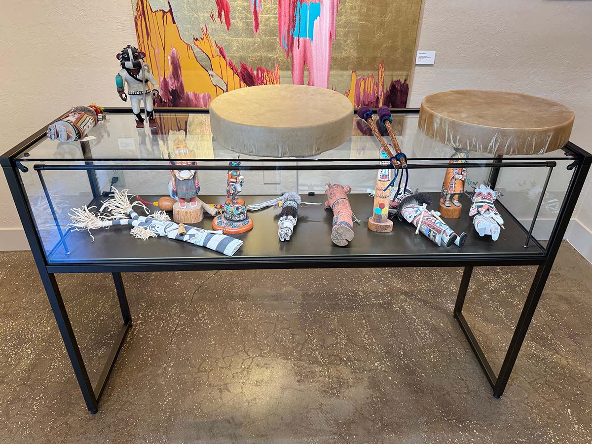 Glass display filled with katsinam with drums placed on top