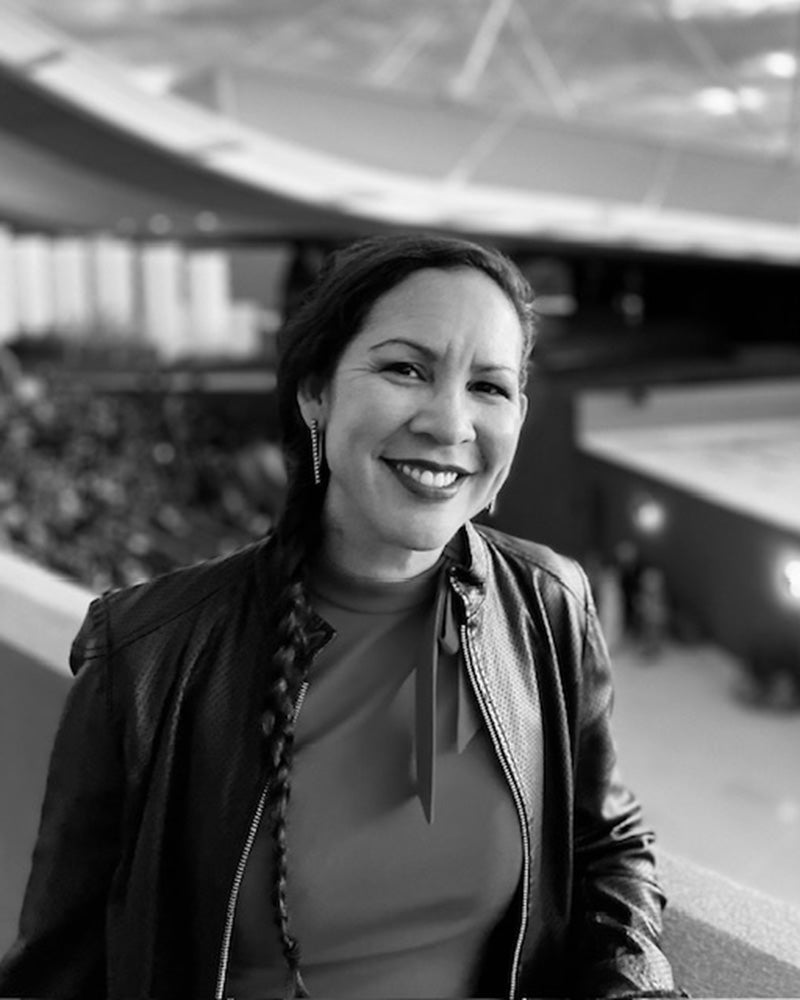 Black and white photo of Marla standing indoors with a blurred background